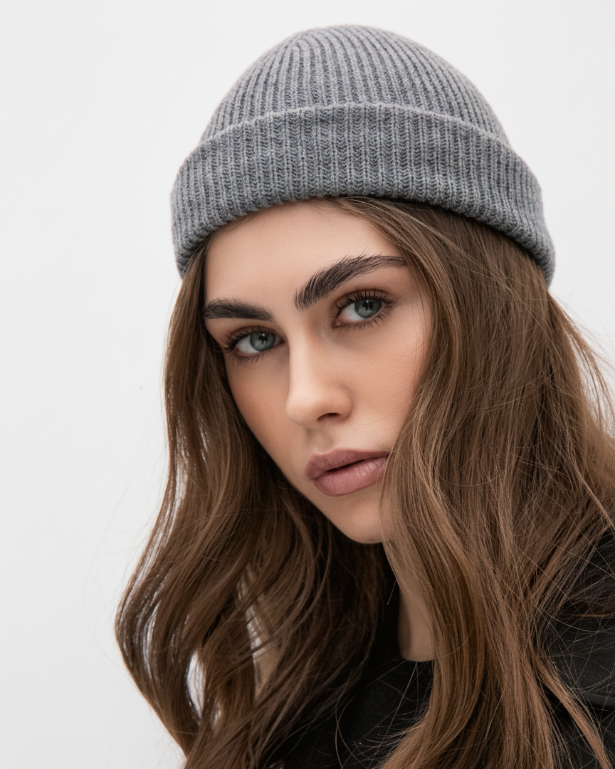 Woman wearing a gray beanie against a white background