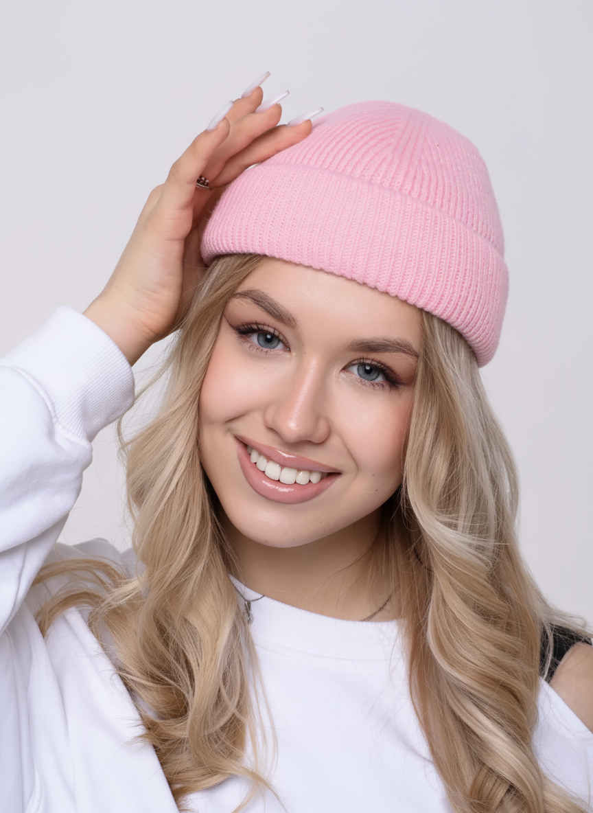 Woman wearing a pink beanie against a plain background
