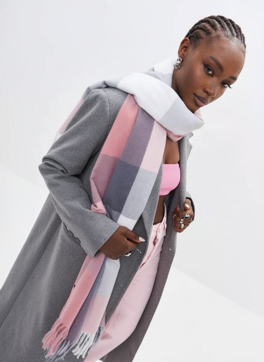 Woman wearing a gray coat and pink top with a colorful scarf on a white background