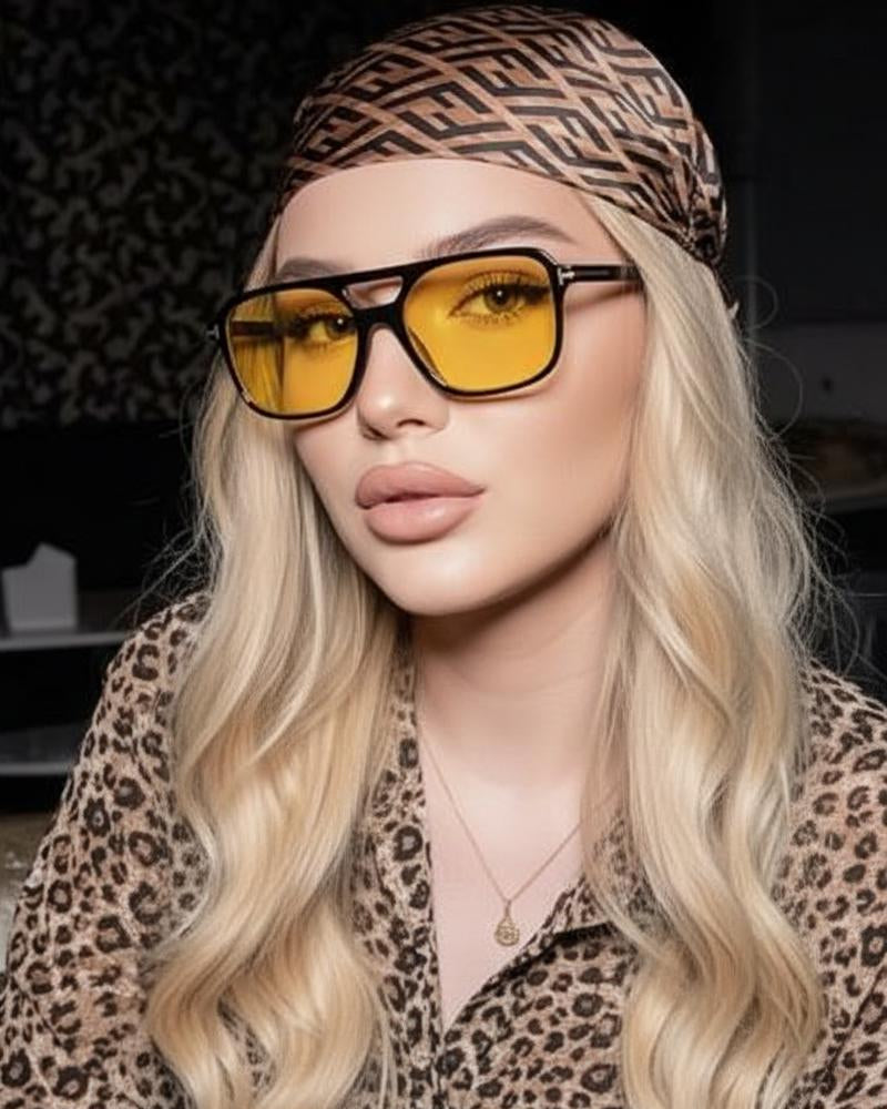 Person wearing a leopard print headband and shirt with yellow sunglasses.