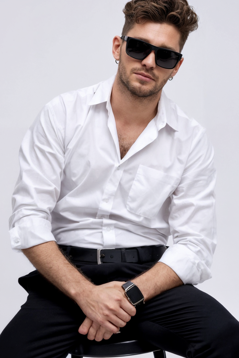 Man wearing a white shirt and sunglasses on a plain background