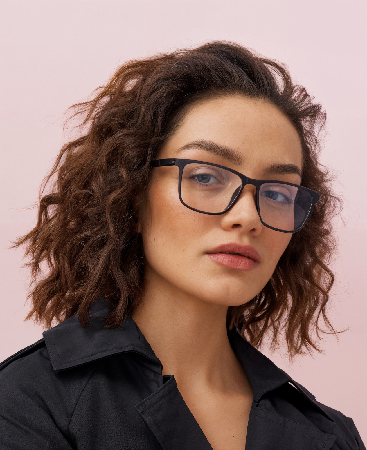Woman wearing glasses with a pink background