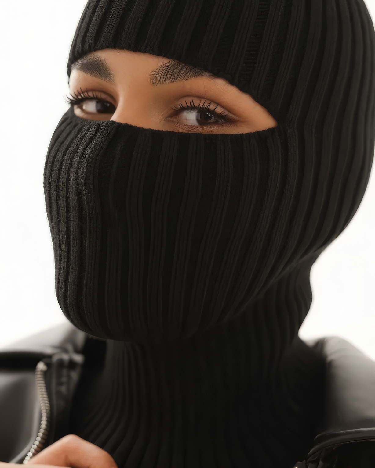 Person wearing a black balaclava with a blurred background