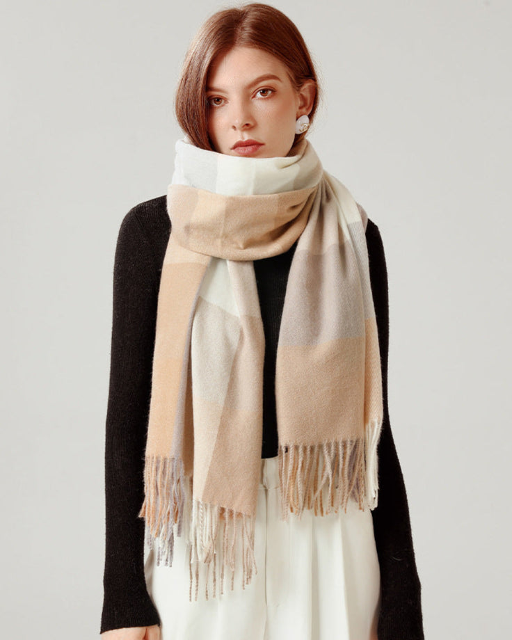 Woman wearing a beige and white checkered scarf on a plain background