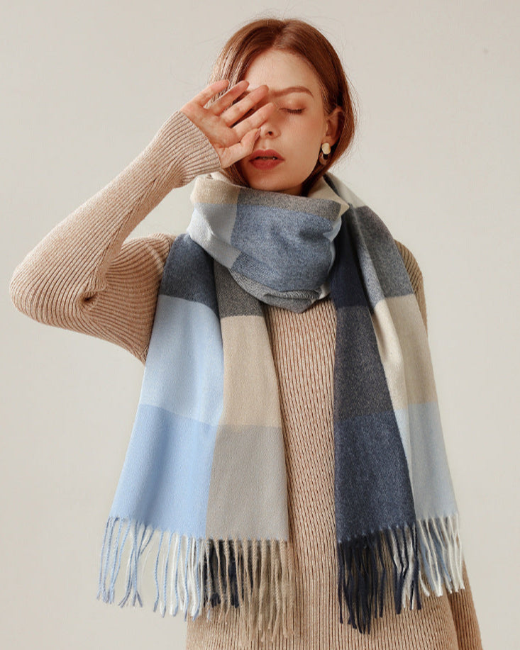 Woman wearing a plaid scarf with a neutral background