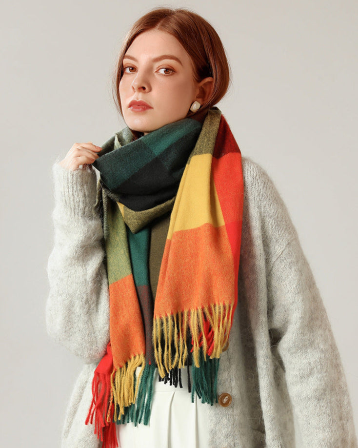 Woman wearing a colorful scarf and gray sweater against a plain background