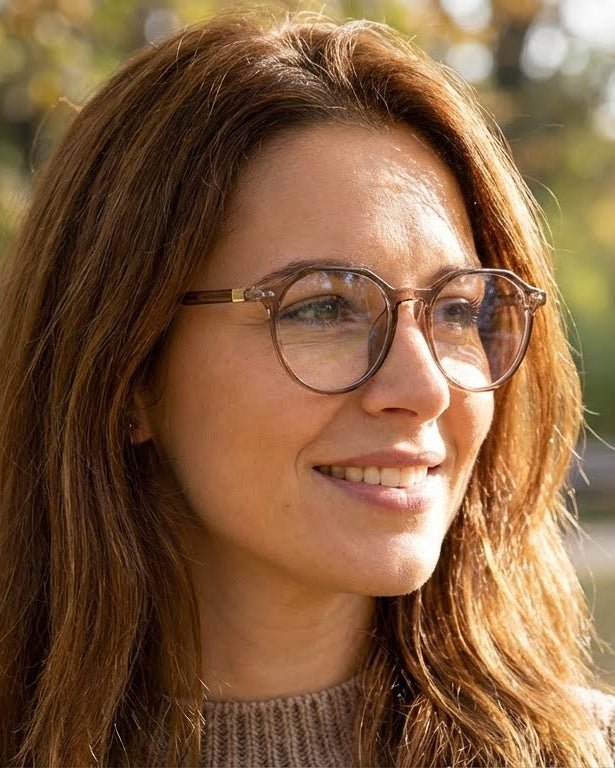 Woman wearing glasses with a blurred autumn background