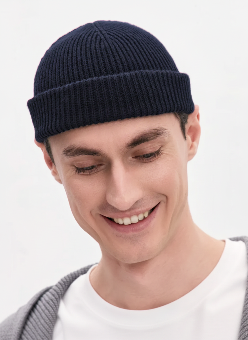 Man wearing a navy blue beanie against a light gray background