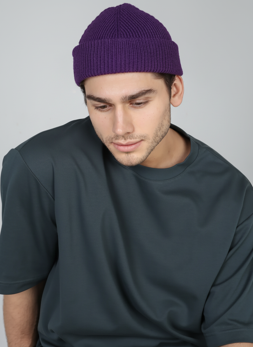 Man wearing a purple beanie and dark gray t-shirt against a plain background