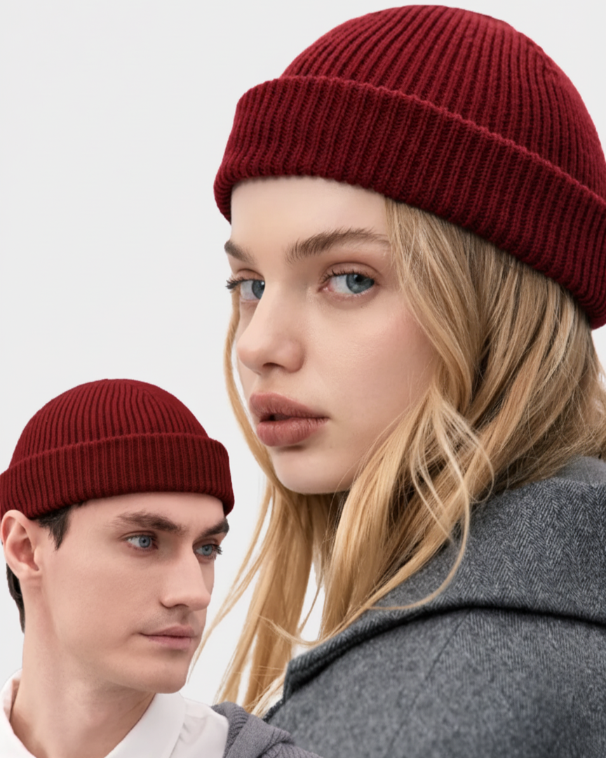 Two people wearing red beanies with a plain background