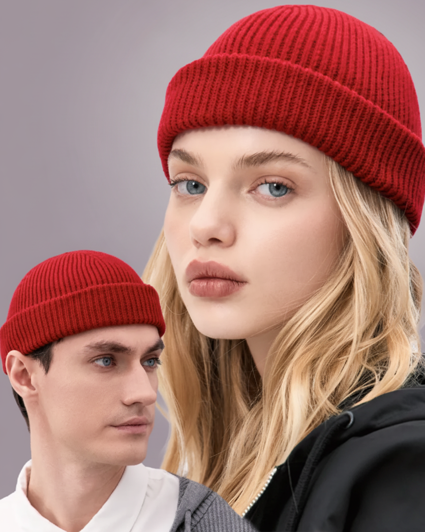 Two people wearing red beanies with a neutral background