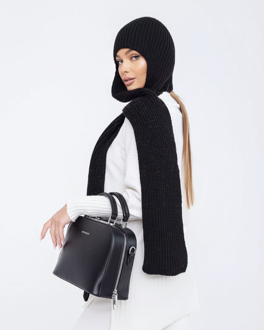 Woman wearing a black knit hat and scarf, holding a black handbag on a white background