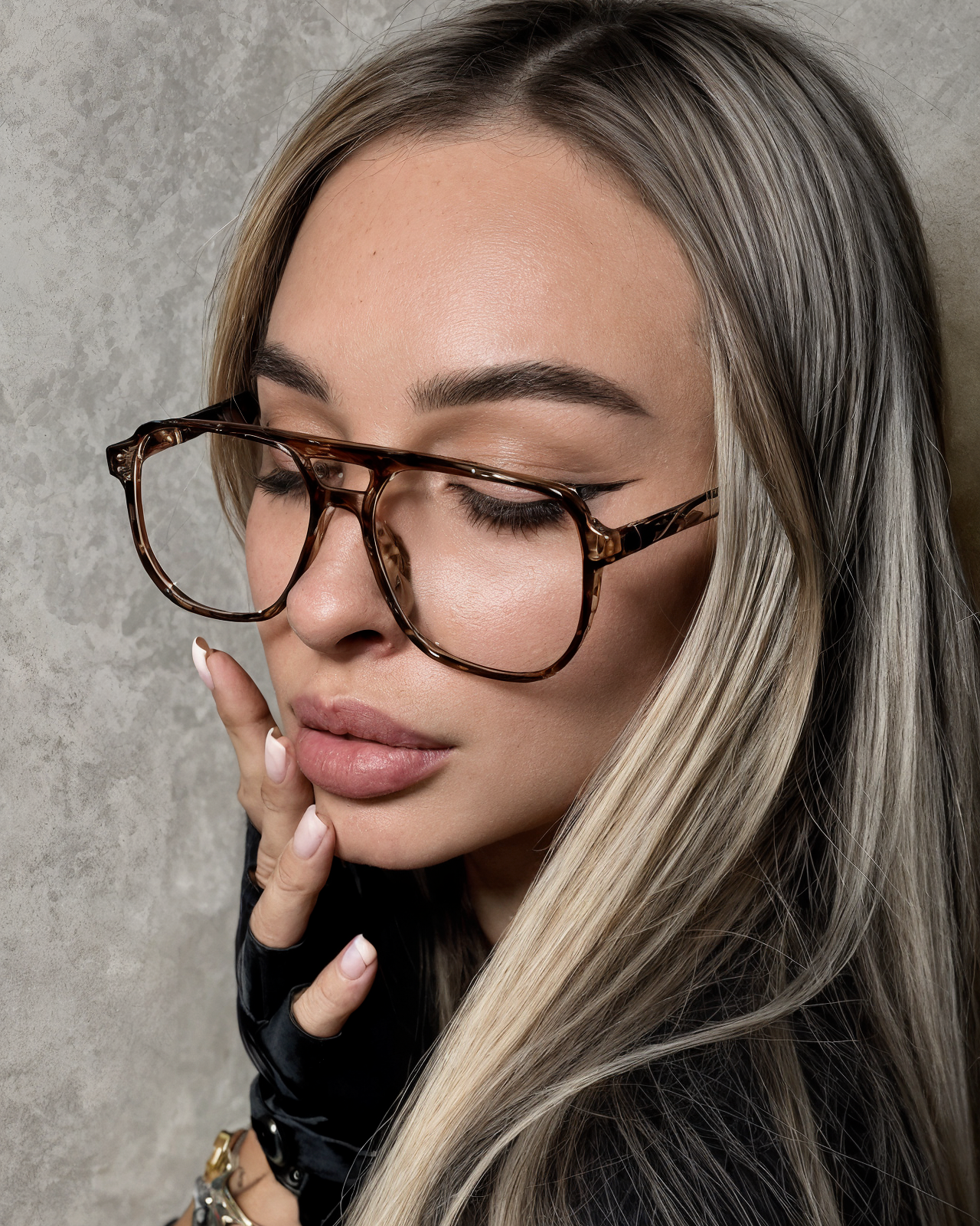 Woman wearing tortoiseshell glasses with a neutral background