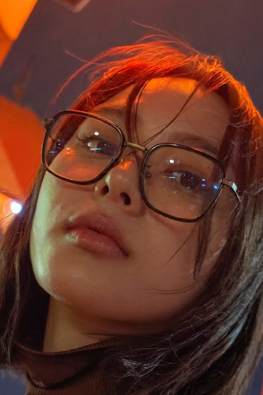 Person wearing glasses with a cityscape background at night