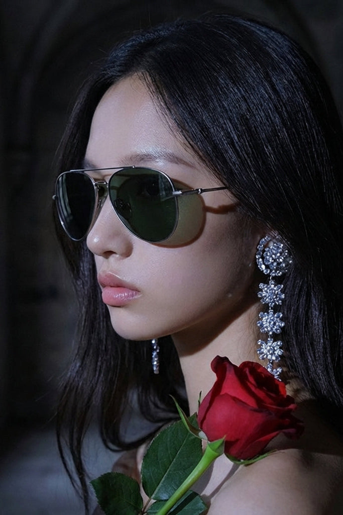 Woman wearing sunglasses and holding a red rose in a dimly lit setting